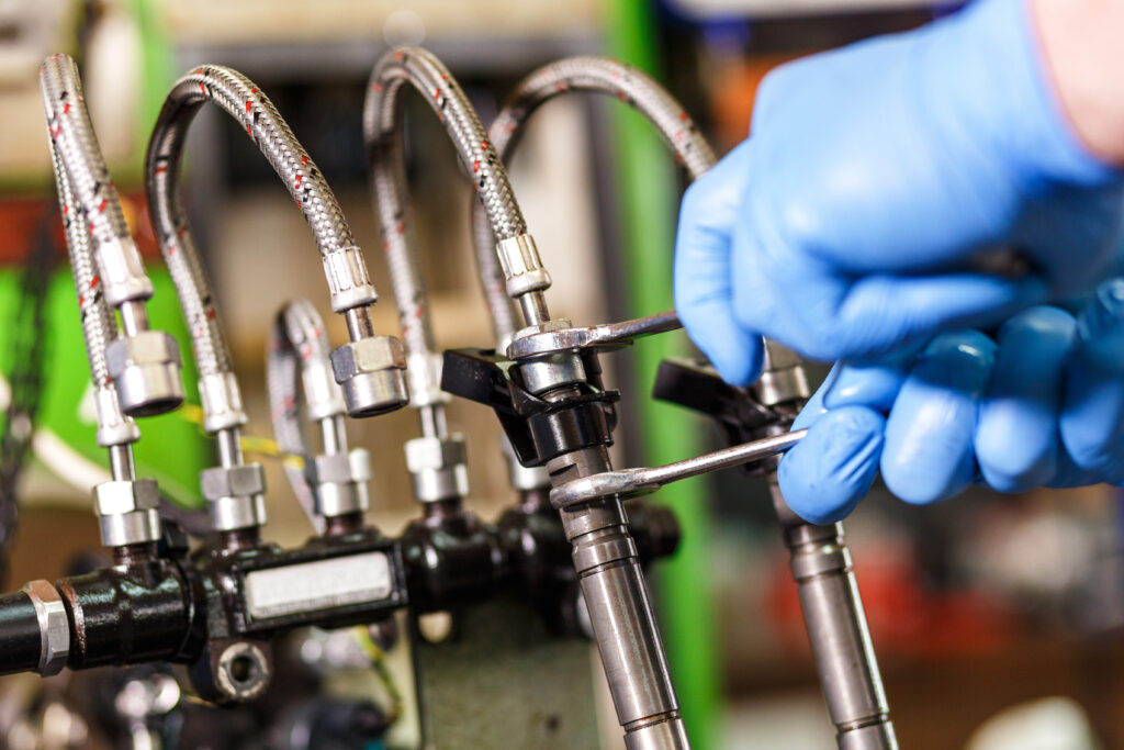 Mechanic testing diesel fuel injector.