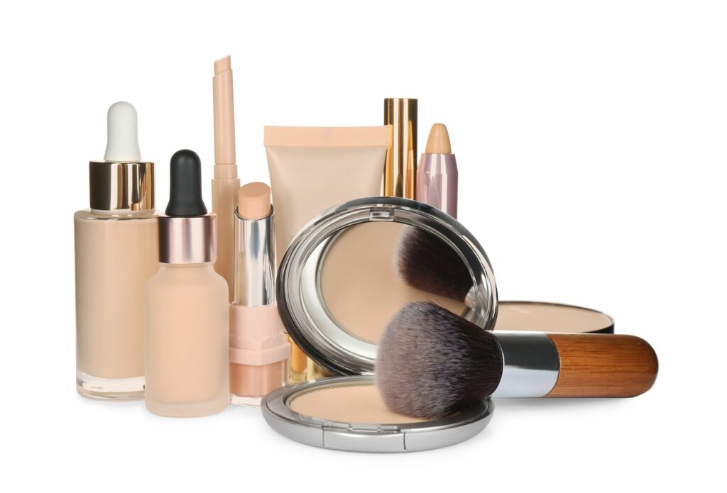 Foundation makeup products including bottles, compacts, and applicators. Zaxis valveless positive displacement metering pumps ensure precise cosmetic dosing.