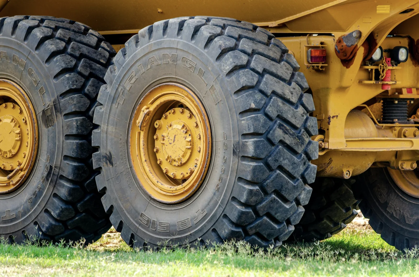 closeup view of large, rugged tires, part of the chassis of an off-highway dump truck